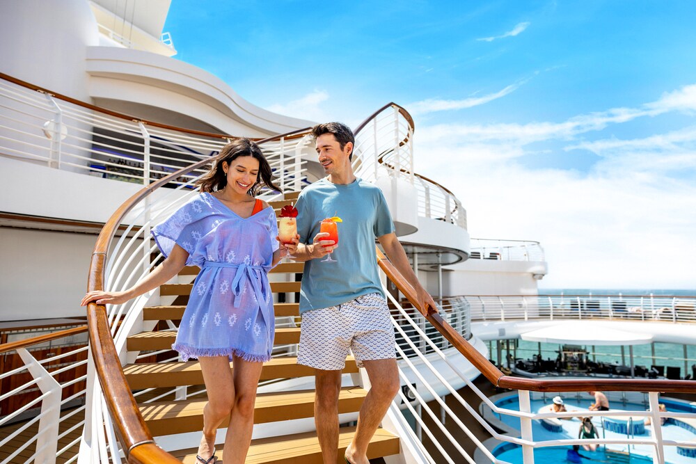 Un hombre y una mujer bajan una escalera en la cubierta del Disney Dream