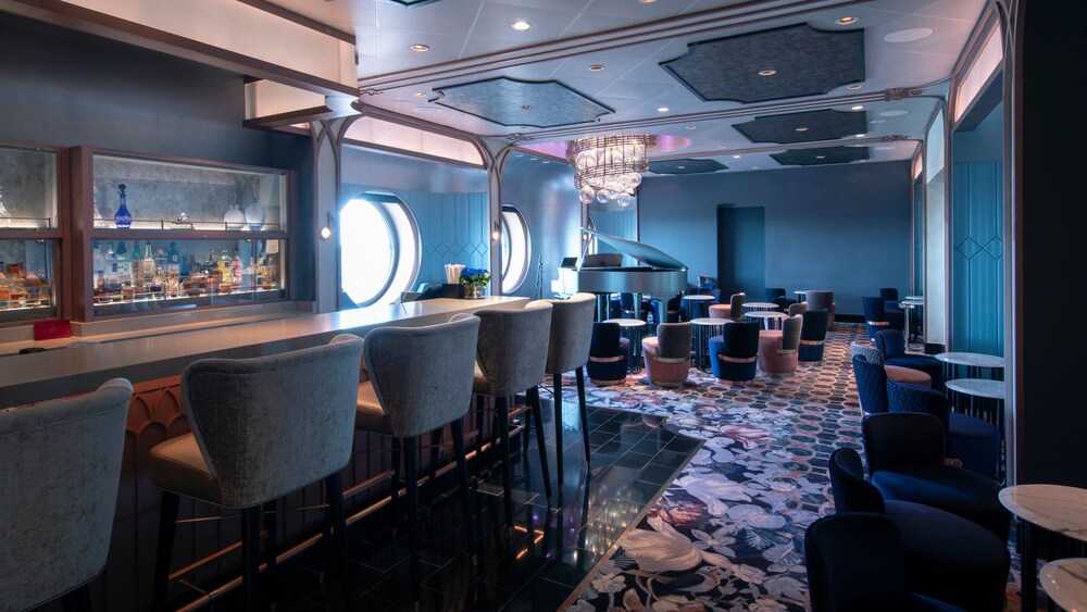 The interior of Nightingale’s reveals an elegant piano lounge with a bar, cushioned seating and port hole windows