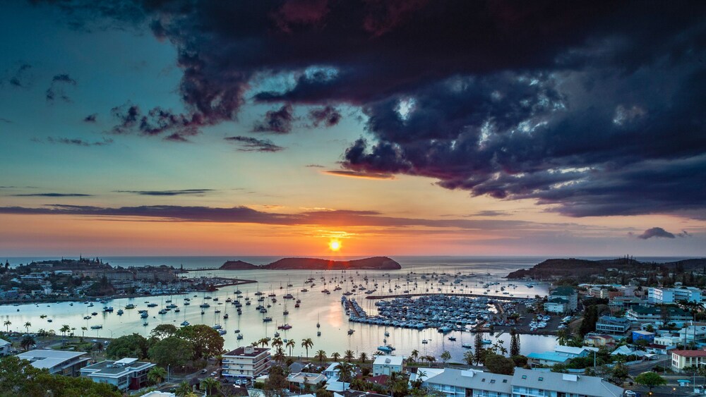 An array of pleasure boats docked in a harbor at sunset 