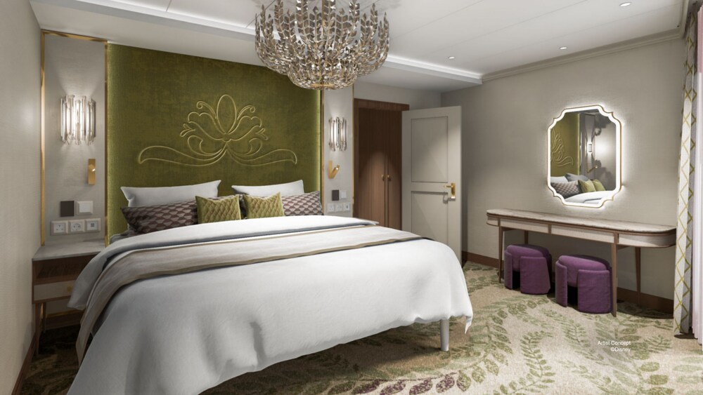 A Concierge Suite with a king size bed, a chandelier and a vanity dresser with a mirror