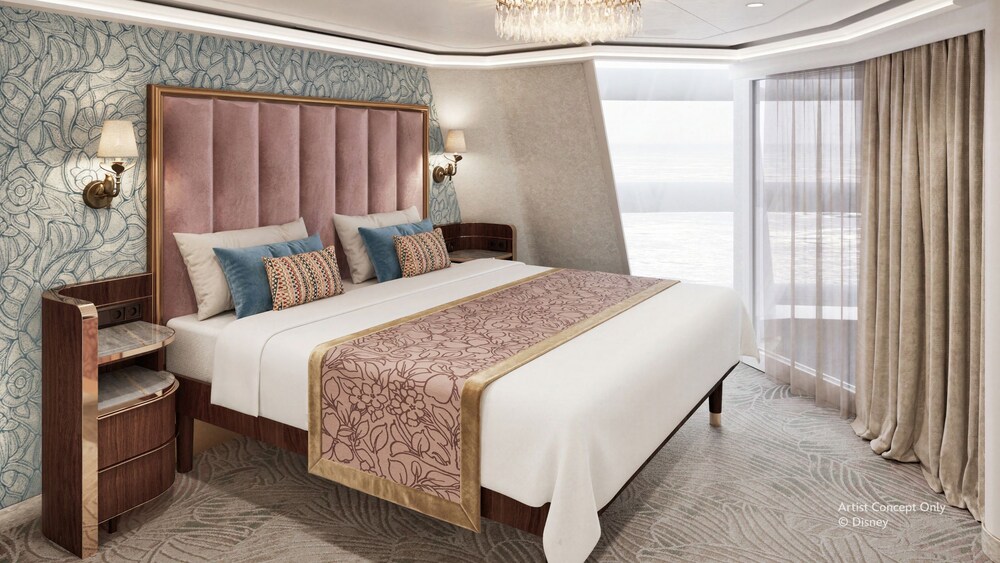 A master bedroom with large windows inside of The Tower Suite on the Disney Believe cruise ship