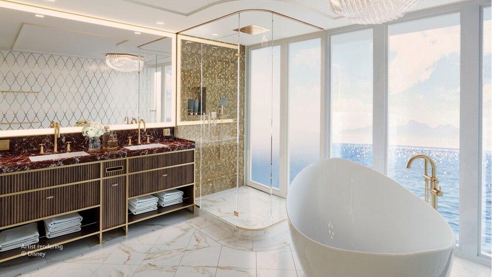 A master bathroom inside of The Beauty and the Beast Royal Suite on the Disney Believe cruise ship, featuring a shower and tub with large windows