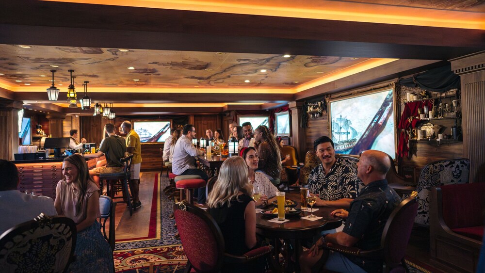 Guests socializing over beverages at Cask & Cannon aboard the Disney Destiny