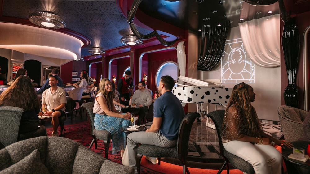 Guests socializing in De Vil's, an elegant 101 Dalmatians themed piano lounge aboard the Disney Destiny