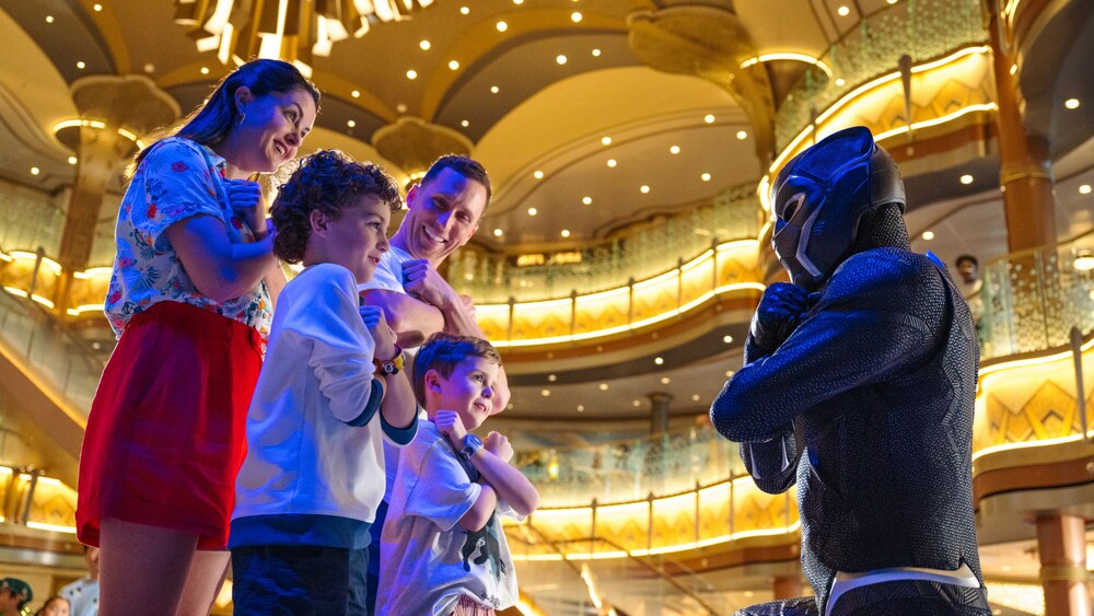 A family enjoying a Character Greeting with the Black Panther aboard the Disney Destiny