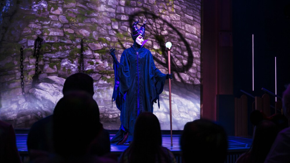 Maleficent scheming in a stage performance of Under Her Spell A Maleficent Encounter