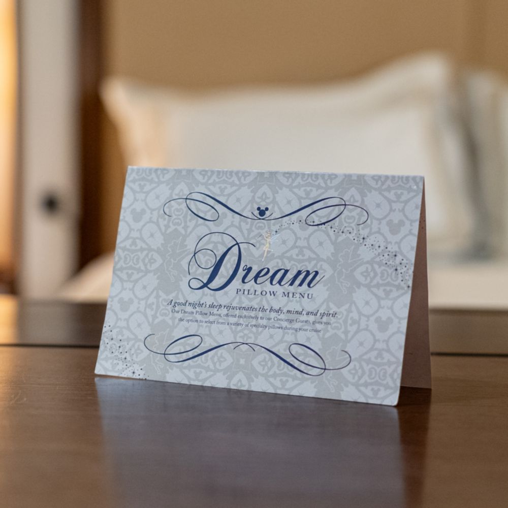 A pillow menu card sitting on a surface at a Disney Dream Concierge Royal Suite with Verandah