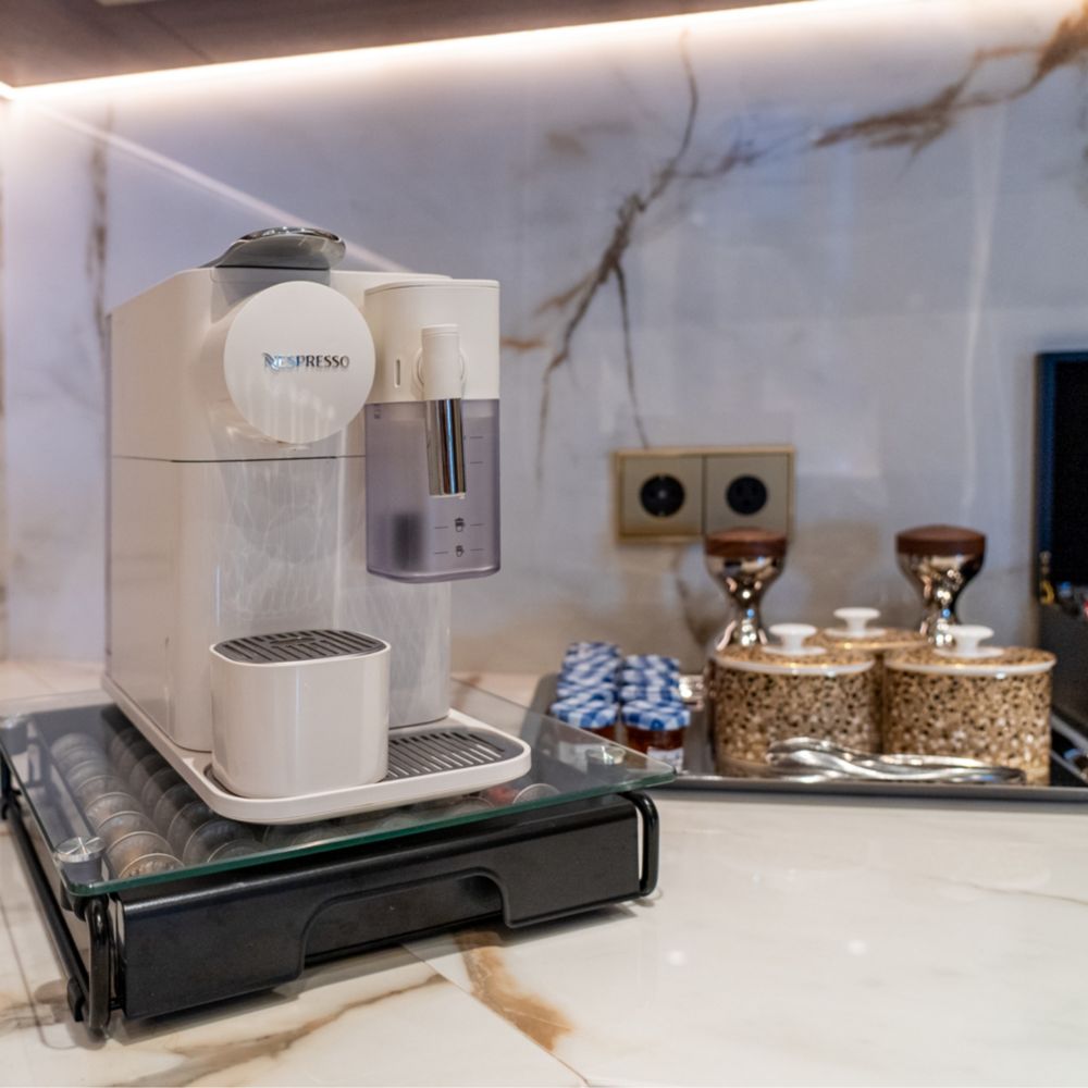 A coffee and tea station with a coffee maker, sweeteners and a tea box in a Disney Dream Concierge Dream Tower Suite