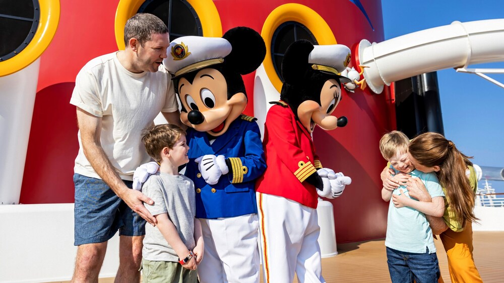 Una familia saluda y abraza a los Capitanes Mickey y Minnie