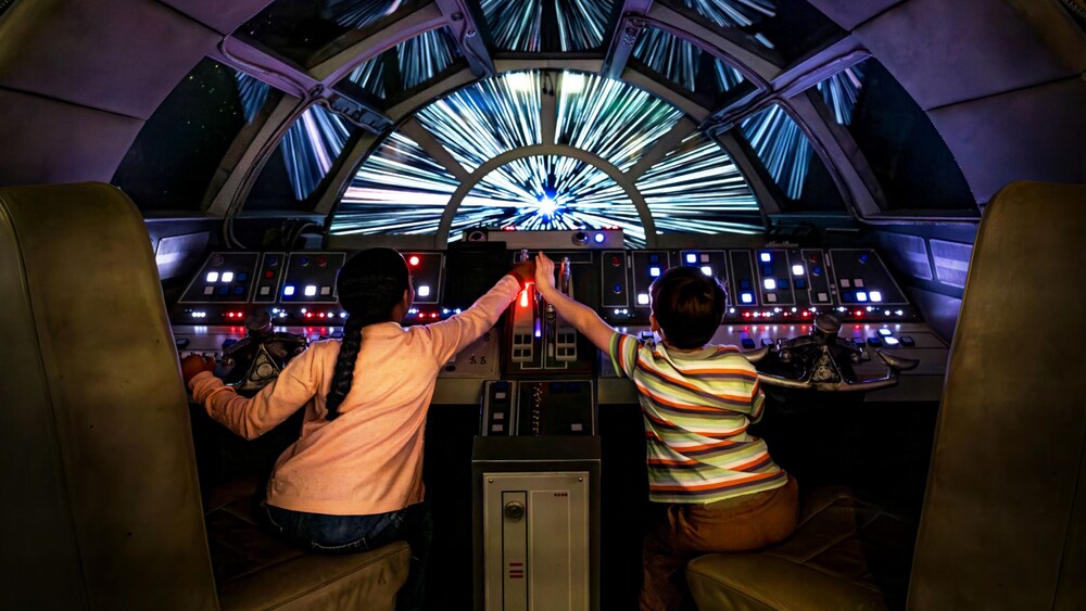 Duas crianças pilotando a Millennium Falcon de Star Wars