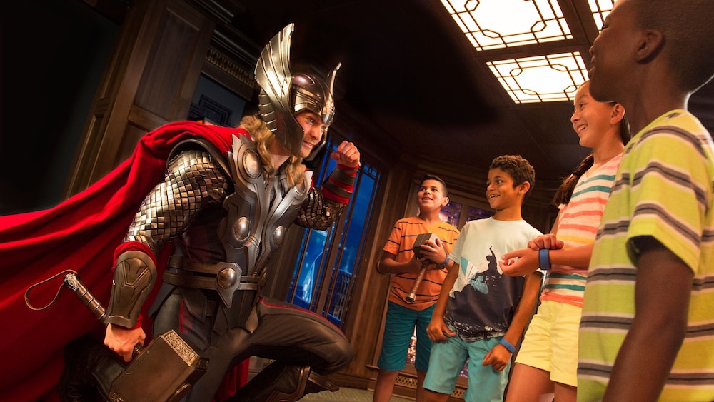 Four Guests smiling and watching Thor pose in a kneeling stance