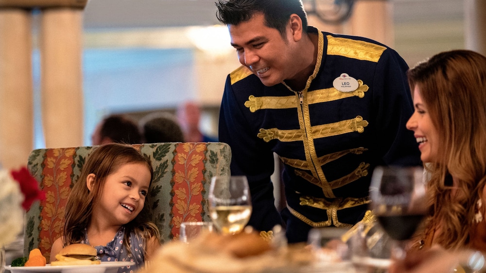 A Cast Member named Leo smiles at a child on board a Disney Cruise Line ship
