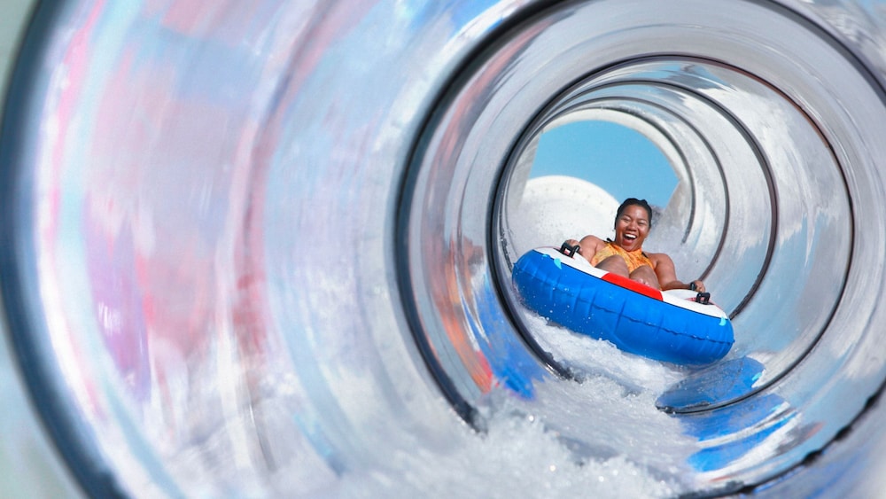 A woman riding a tube on the Aqua Duck water slide on board the Disney Fantasy cruise ship