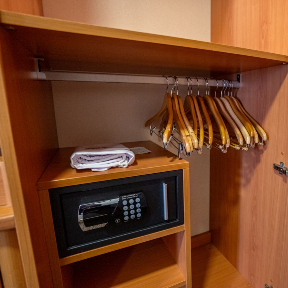 A closet with a safe in a Disney Magic Deluxe Oceanview Stateroom with Verandah