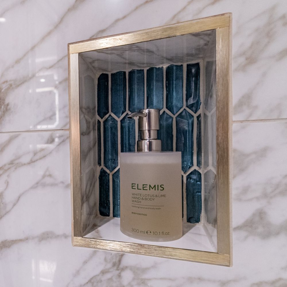 A bathroom with a walk in shower and Elemis hand & body wash in a Disney Magic Concierge 1 Bedroom Suite with Verandah