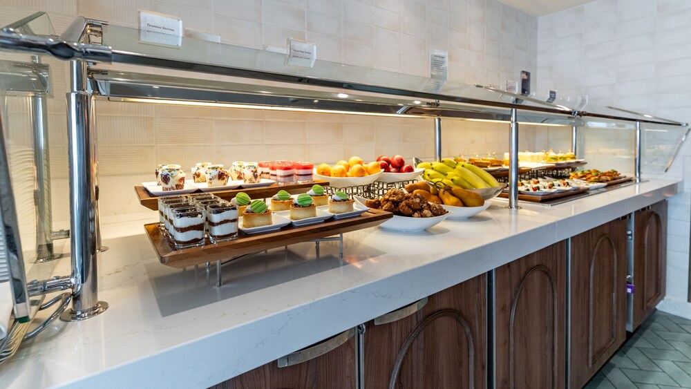 A buffet with desserts, fresh fruit, sandwiches and appetizers in the Disney Magic Concierge Lounge