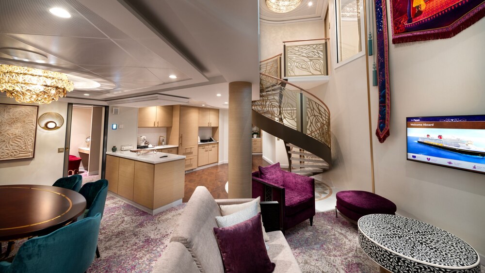 An artist rendering of a Disney Treasure 2 Story Royal Suite with Verandah Stateroom with a dining table, a kitchen, stairs, a TV, a chair, a sofa and a low table