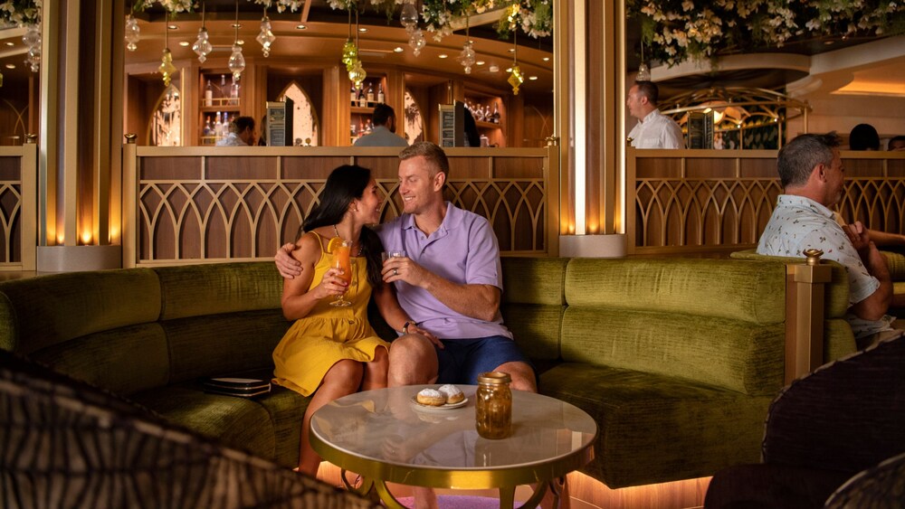 A man and a woman enjoying beverages and smiling at each other at The Bayou