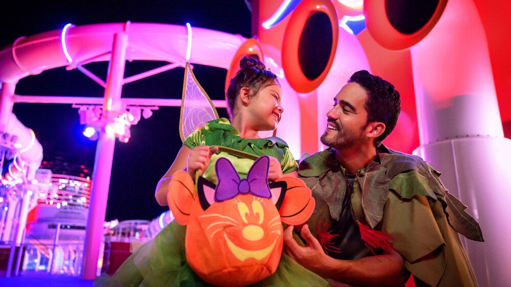 A father and his daughte, dressed as Peter Pan and Tinker Bell on a Disney Cruise Line ship at night