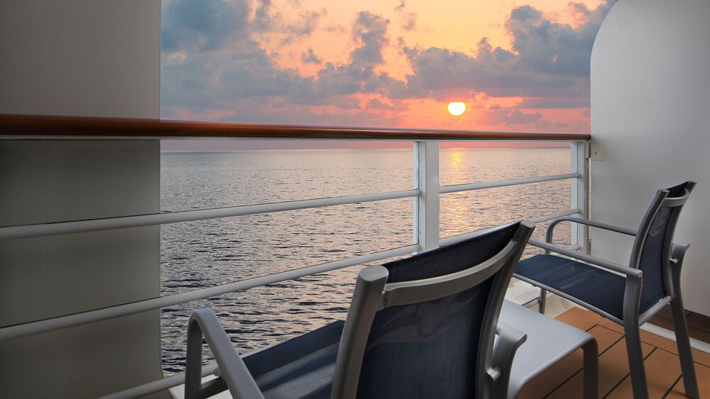 Two chairs and a table on a verandah facing the ocean