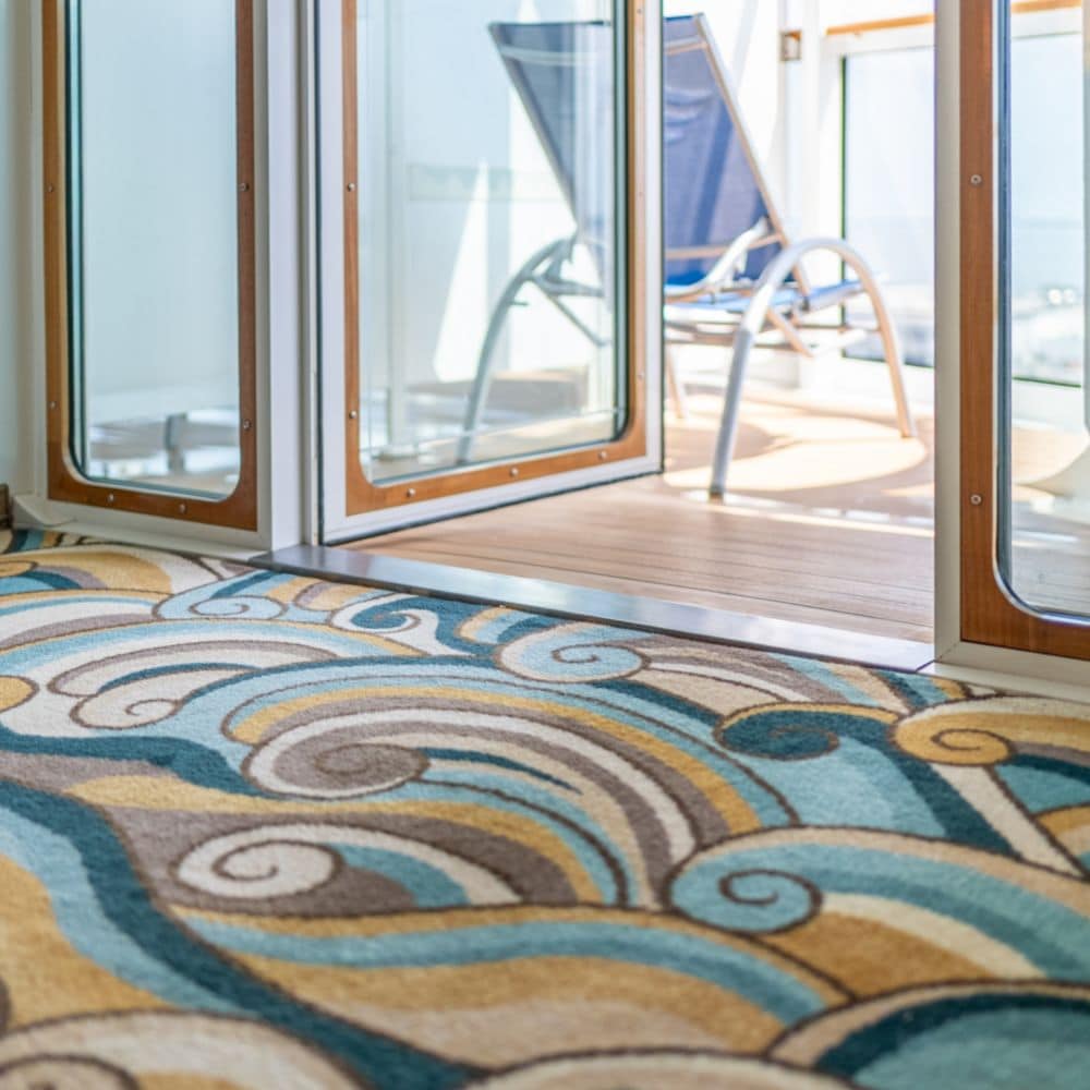 A Disney Cruise Line Concierge 2 Bedroom Suite with Verandah carpet with an ocean wave pattern leading to the verandah