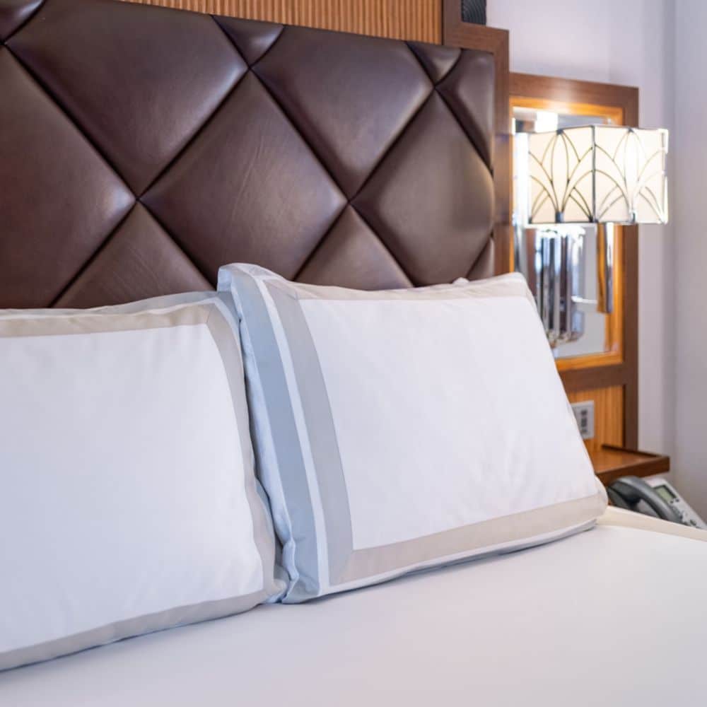 Pillows on a stateroom bed leaning against a padded headboard