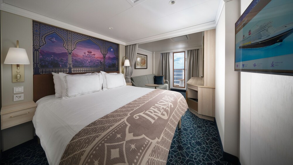 An artist rendering of a Disney Treasure Deluxe Oceanview with Verandah Stateroom with a bed, artwork inspired by Aladdin, a sofa, a verandah with an ocean view, a vanity and a TV