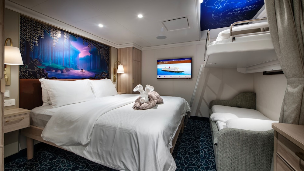 An artist rendering of a Disney Treasure Inside Stateroom with a bed, a TV, a bunk bed, a sleeper sofa and a vanity