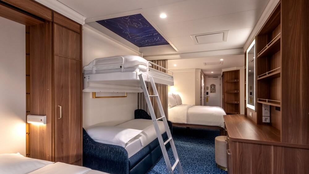 A Disney Wish Deluxe Oceanview Stateroom with Verandah featuring a desk, mirror, 2 beds and 2 bunk beds