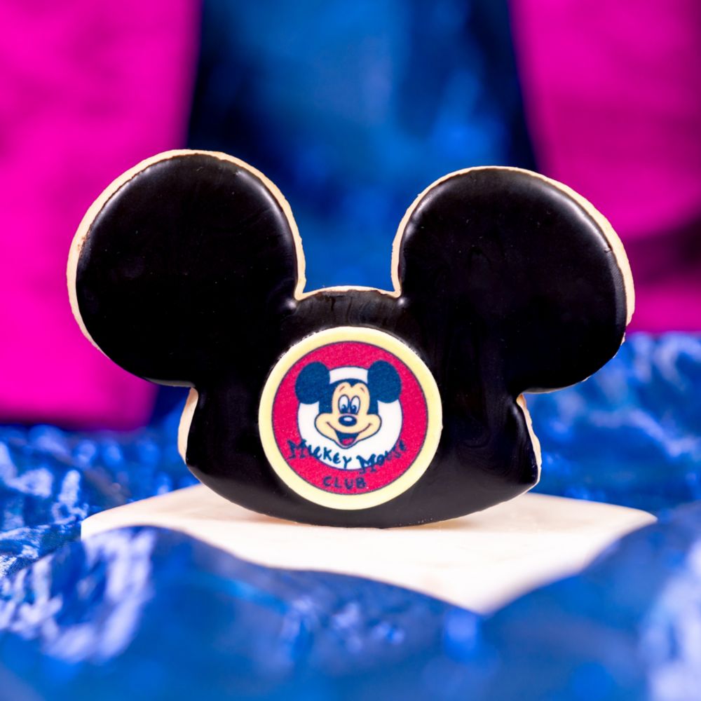 A cookie shaped like a Mickey Mouse ear hat featuring a Mickey Mouse Club logo