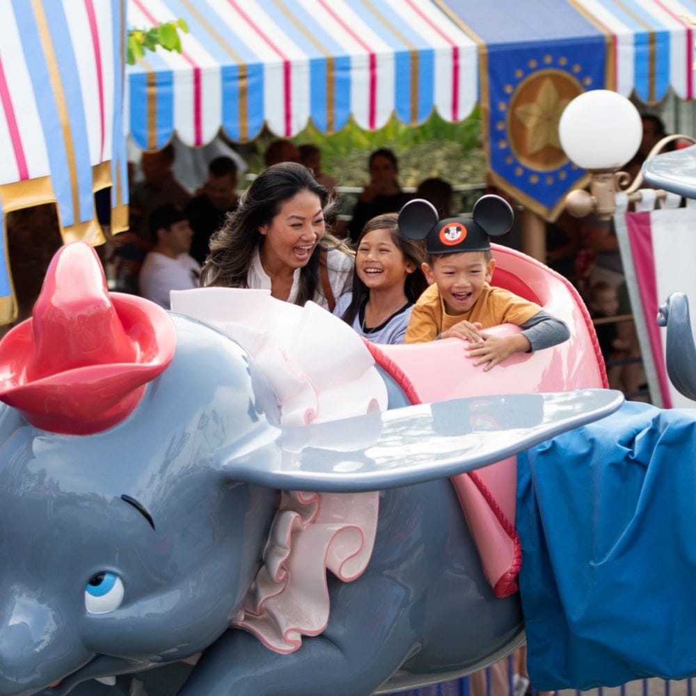 Madre e hija paseando en Dumbo the Flying Elephant en Disneyland Park