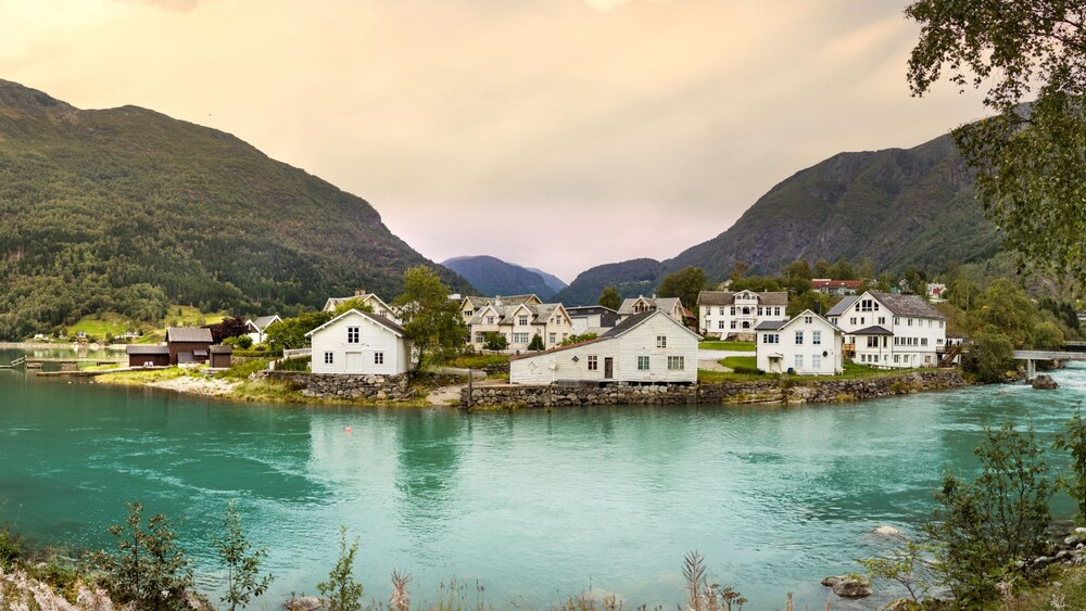 The scenic village of Skjolden in Norway, with wooden houses surrounded by mountains and river waters