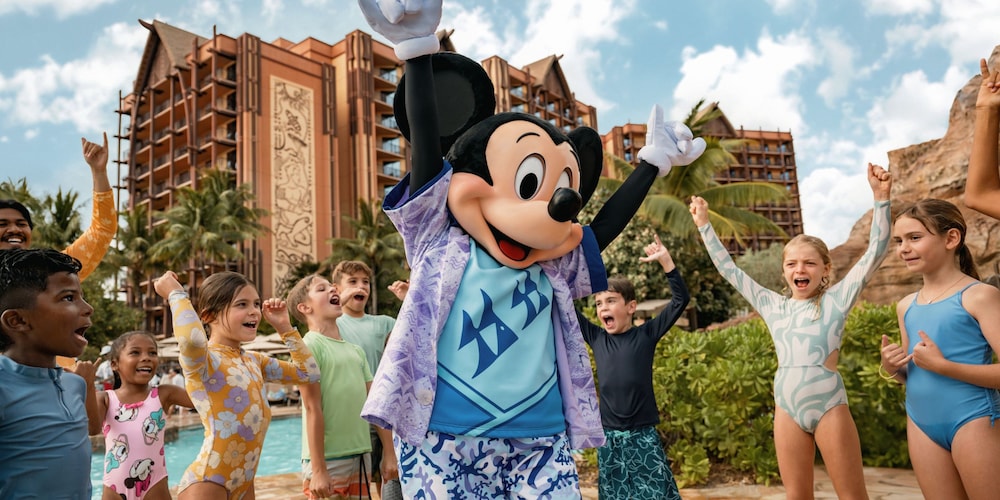 Mickey Mouse dancing with a group of children next to one of the pools at Aulani, A Disney Resort & Spa