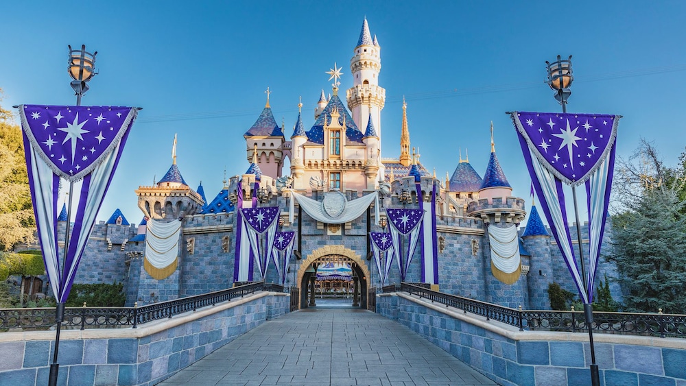 Disney100 セレブレーションを記念して上品なバナーやバンティングで飾られた眠れる森の美女の城