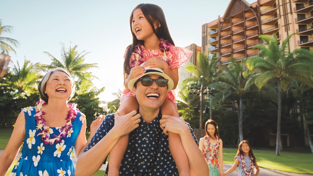 3 children, their mother, father and grandmother walking outdoors at Aulani Resort