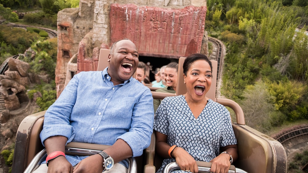 A man and woman screaming with joy while riding the Expedition Everest attraction