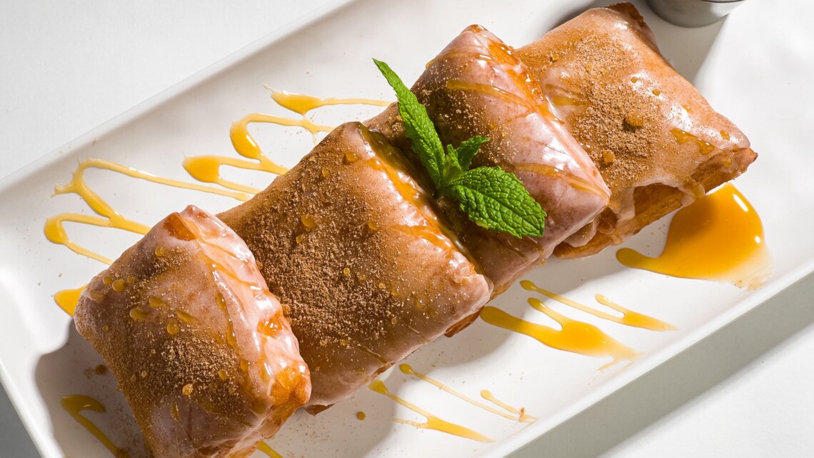 A bowl of blueberry beignets, topped with a dusting of cookie crumbs