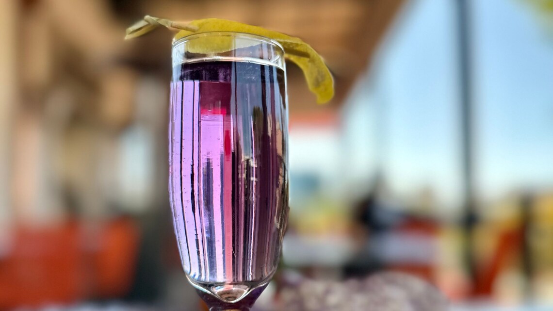 A beverage served in a champagne flute and garnished with a leaf