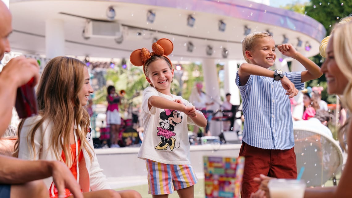 Two children dancing while standing near their family