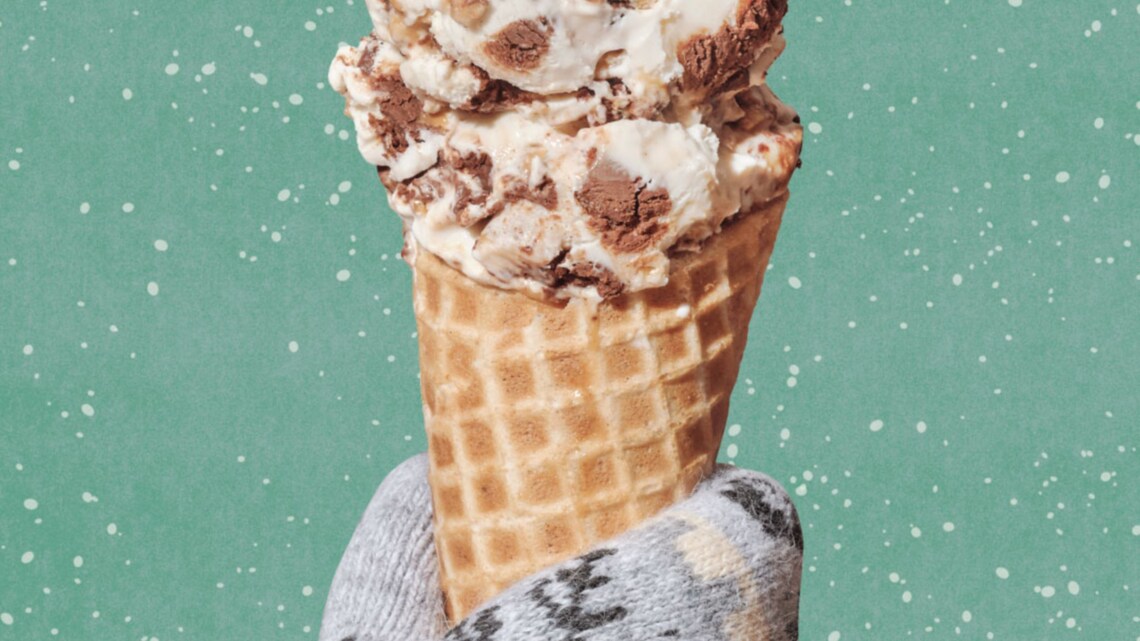 Una mano con guante sosteniendo un cono de helado de masa de galleta de jengibre de Salt & Straw