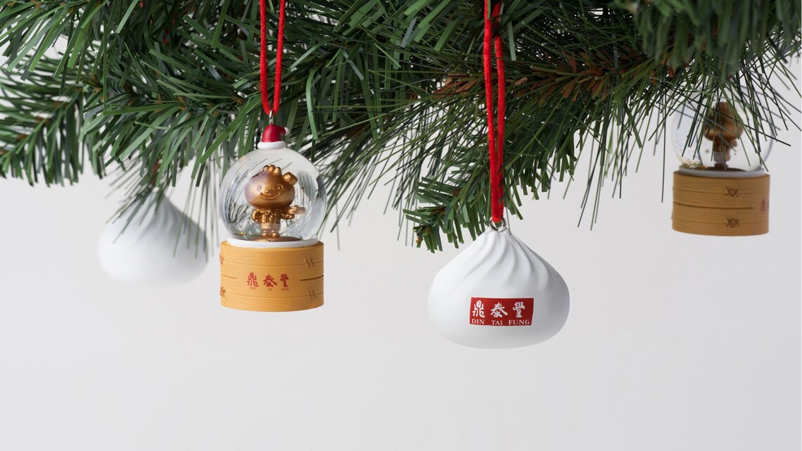 Adornos navideños de Din Tai Fung colgando de una rama de árbol de Navidad