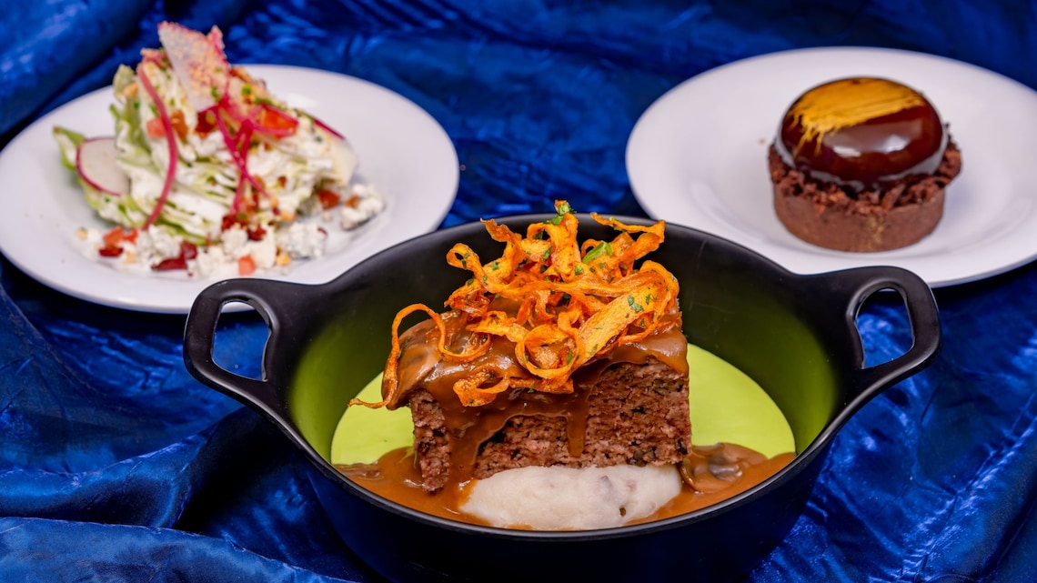 Una ensalada de cuña pequeña, un pastel de carne glaseado con salsa de champiñones y un pastel de chocolate, todo parte del Paquete de Comida Paint  The Night de Plaza Inn