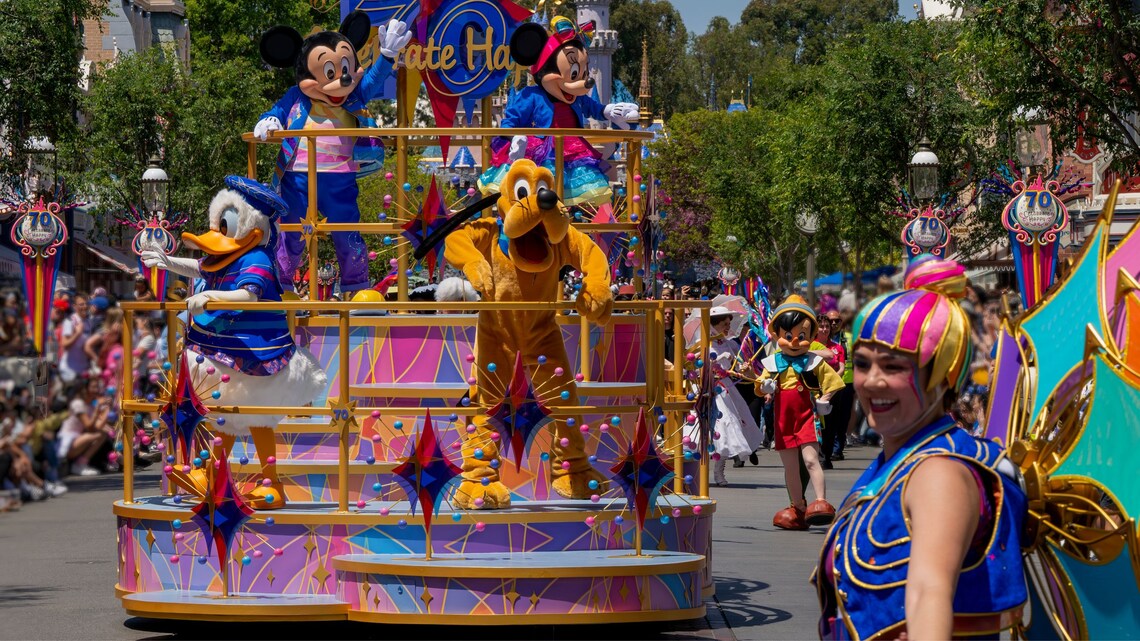 Mickey Mouse, Minnie Mouse, Donald Duck y Pluto en una carroza durante Celebrate Happy Cavalcade