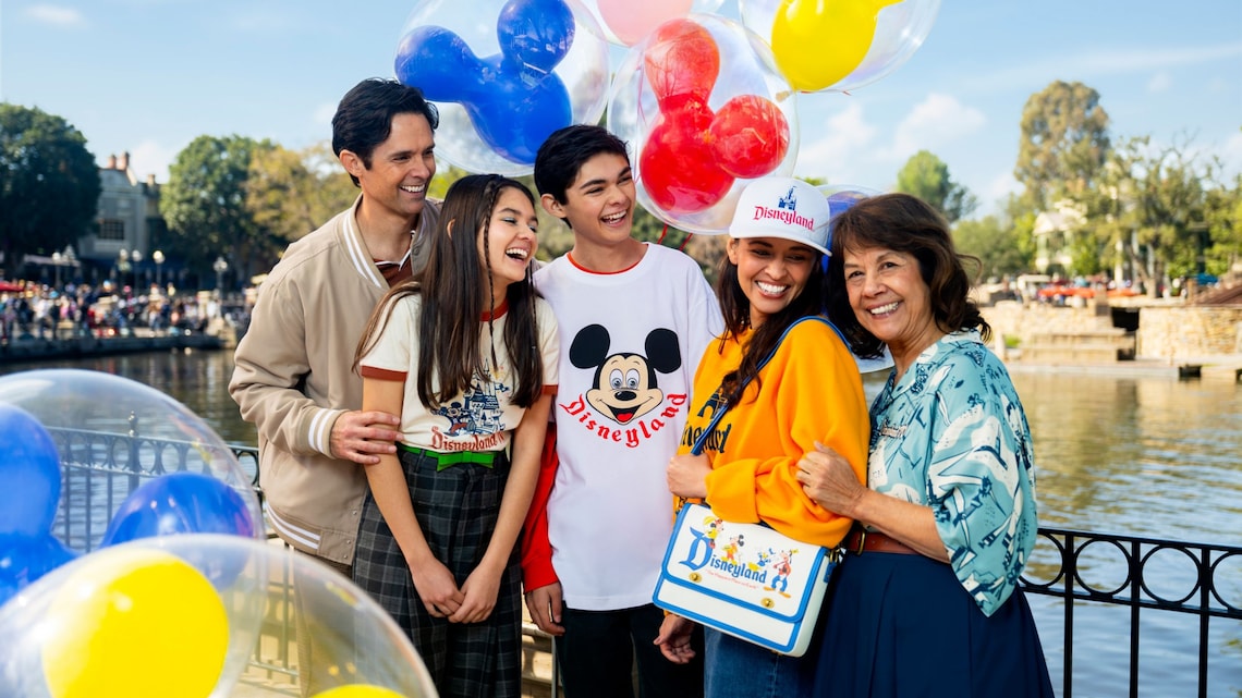 Un grupo de Visitantes con sombrero, camisa de manga larga, bolso, sudadera y camiseta de la Celebración del 70.º Aniversario del Disneyland Resort