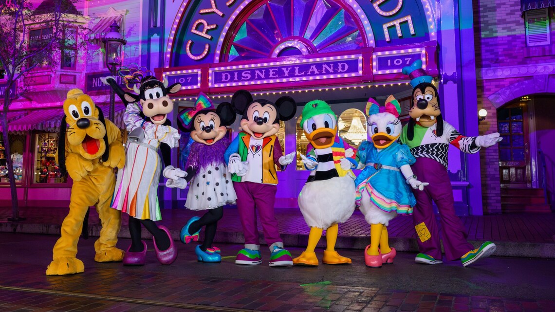 Pluto, Clarabelle Cow, Minnie Mouse, Mickey Mouse, Donald Duck, Daisy Duck and Goofy posing for a picture in front of Crystal Arcade in Disneyland Park
