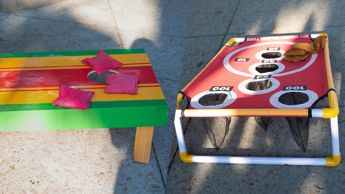 A cornhole board and a ring toss game set up outdoors at Disney on the Yard: Yardfest