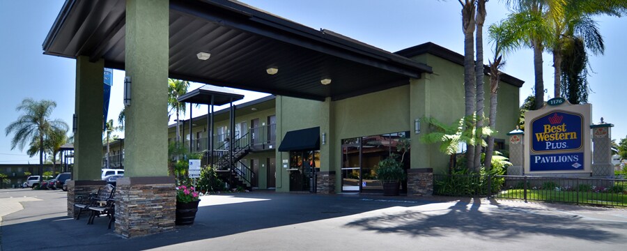 The carport overhang and entrance to Best Western Plus Pavilions accented with palm trees