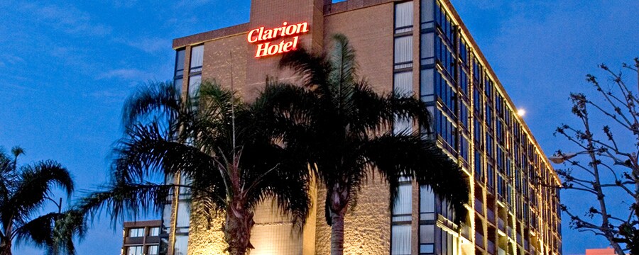 Palm trees accent the ground around the Clarion Hotel Anaheim Resort lit up at night