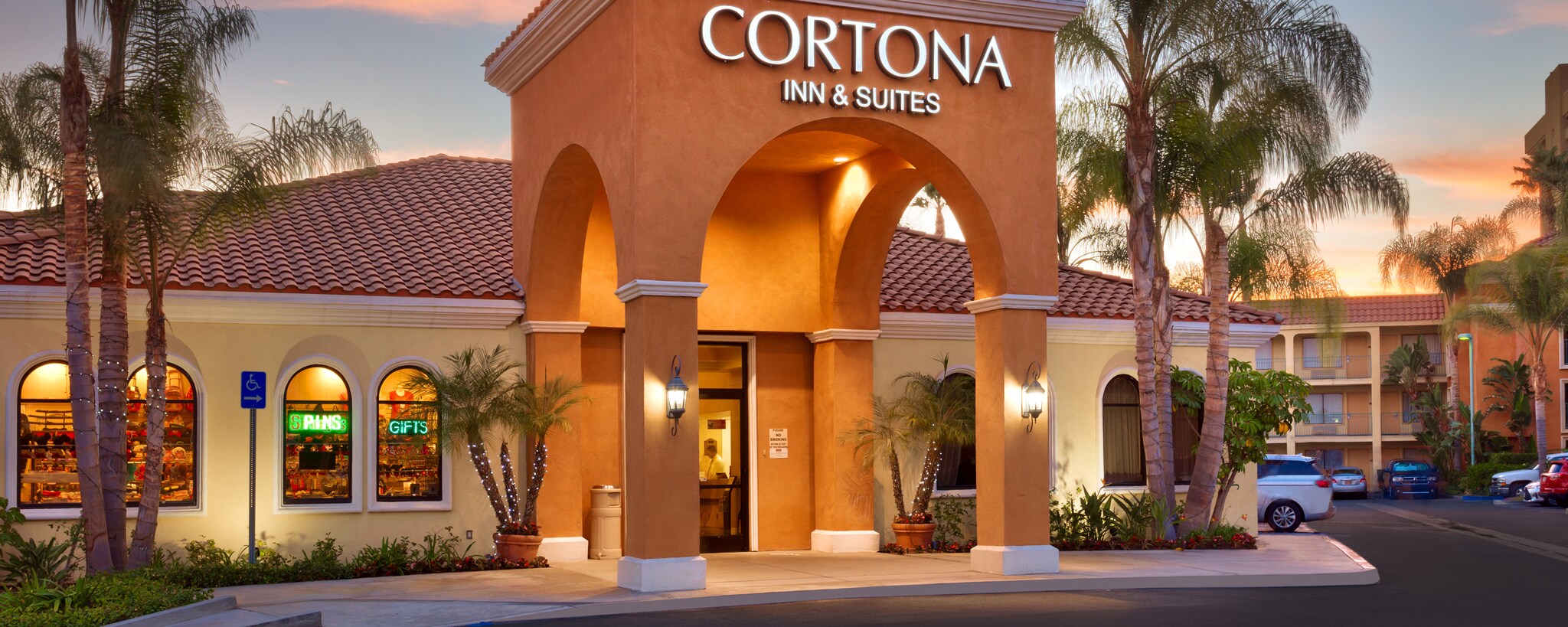 The parking lot and entrance to Mission-style Cortona Inn & Suites Anaheim Resort