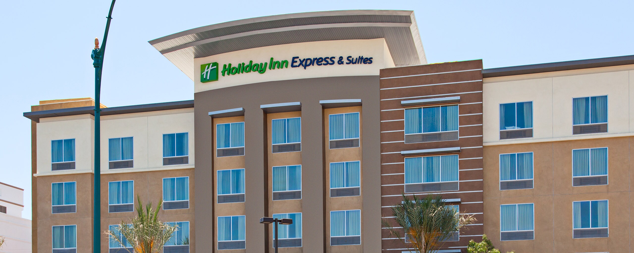 The front of a hotel with a sign that reads Holiday Inn Express and Suites